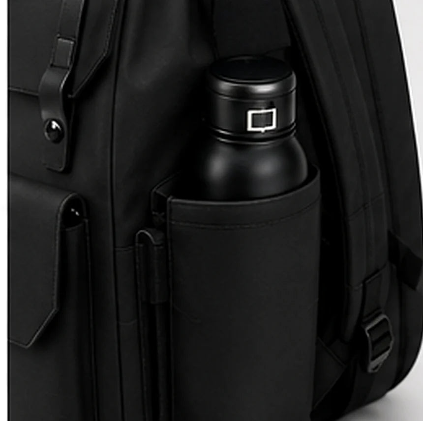 A water bottle held in the side pocket of a black DRAEN backpack