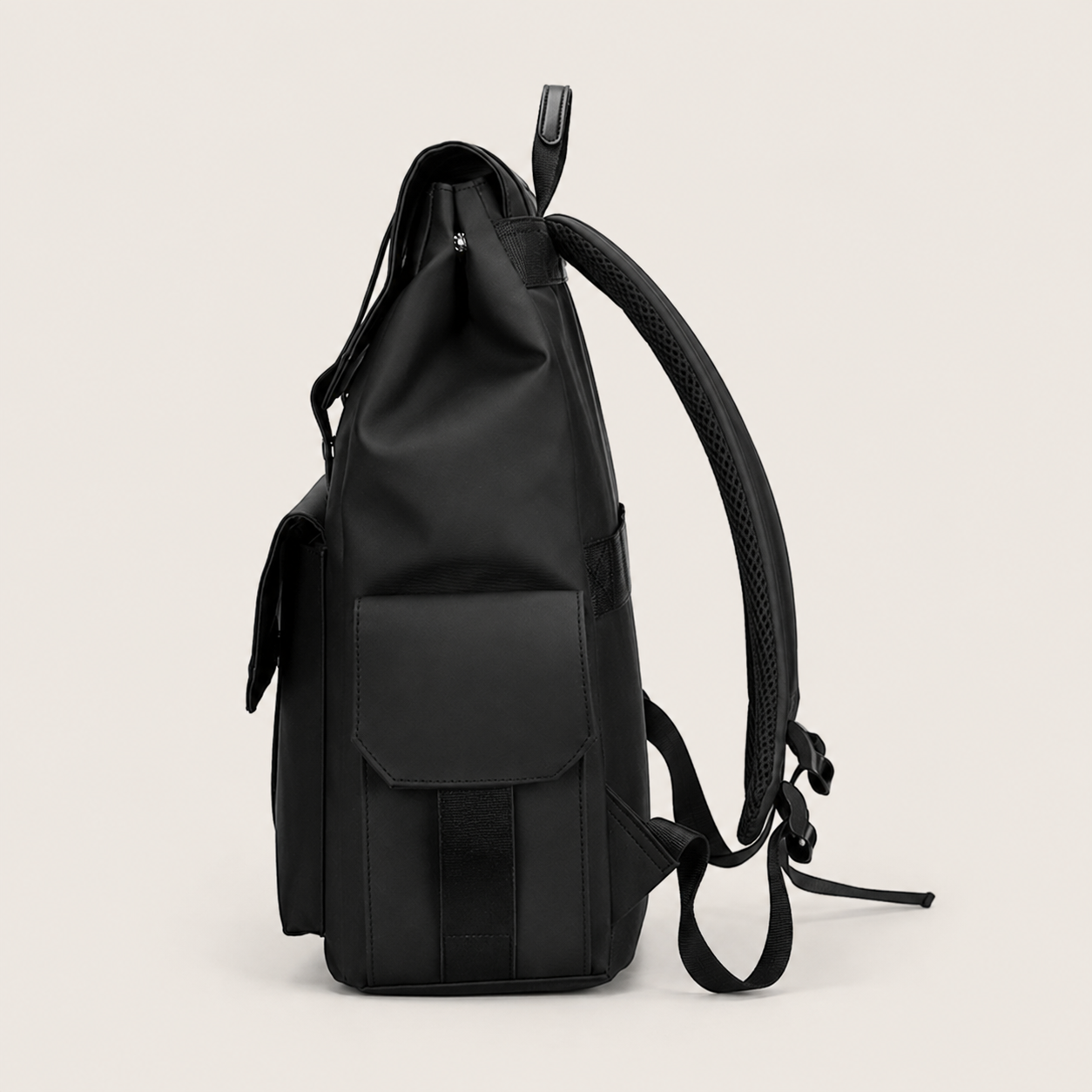 Side profile of the black DRAEN backpack showing its depth and front flap